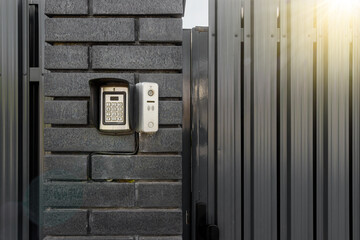 Intercom and security camera on the brick wall outside residential building - obrazy, fototapety, plakaty