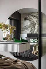 Interior design of harmonized bedroom with beautiful mirror, shelf, modern bed, flowers in vase,...