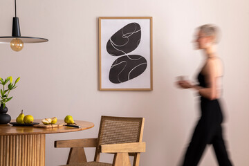 Warm and cozy interior of living room space with mock up poster frame, round table, chairs, pedant...