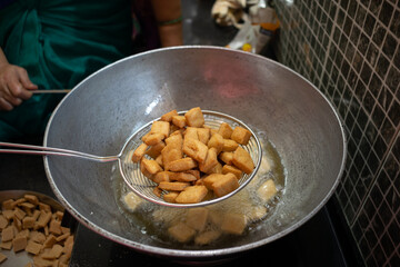 Hot fried snacks being taken out from the kadhai or pan full of oil, ghee, butter. Shanka pali, shakkar para, sweets, namkeen, deep fry, Diwali, Deepawali, faral, prasad, dish, healthy, cholesterol.