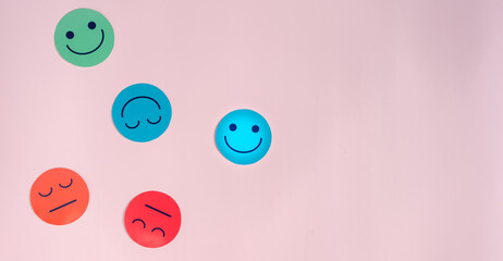 Happy smiley face paper cut which is among various emotions, good feedback rating and positive customer review, experience, satisfaction survey ,mental health positive life concept.