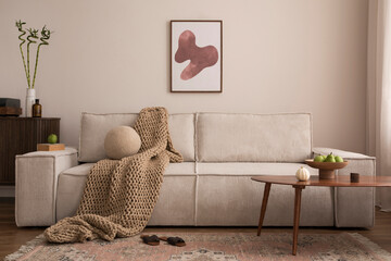 Interior design of living room with mock up poster frame, modern beige sofa, blanket, wooden coffee table, vase with dried flowers, round pillow, commode, vintage carpet and personal accessories. 