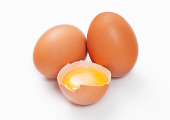 Raw fresh organic eggs with shell and yolk on white background.