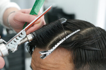 Close-up of a man's hair perming with a hairdressing tool