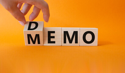 Demo and Memo symbol. Businessman hand turns wooden cube and changes word Memo to Demo. Beautiful...