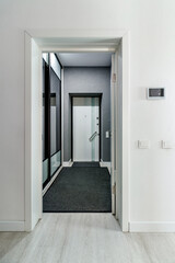 Entrance hall attached to small modern living room, doors to wardrobe opened.