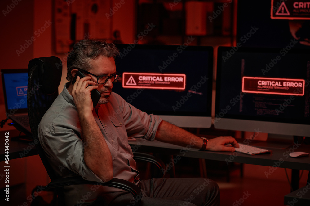Poster serious mature programmer or director of large modern it support department or company talking on mo