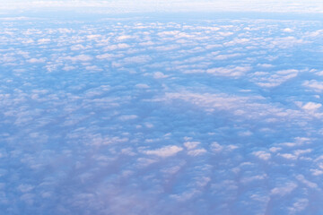 Background of a pink heavenly sky with fluffy dense clouds, top view from an airplane. Can be used as advertising background, overlay. Travel concept.