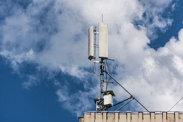 5G antenna on a construction roof on a cloudy sky in town