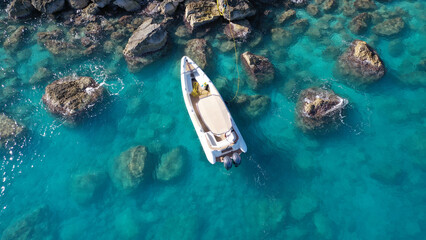Aerial drone photo of small inflatable rib speedboat anchored in beautiful bay of small fishing...