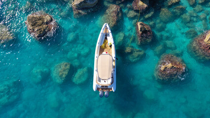 Fototapeta na wymiar Aerial drone photo of small inflatable rib speedboat anchored in beautiful bay of small fishing coastal village of Assos in island of Kefalonia, Ionian, Greece
