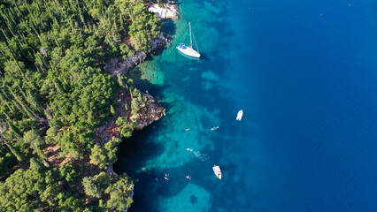 Aerial drone photo of beautiful bay and beach of Foki with iconic caves visited by yachts and sail boats, Kefalonia island, Ionian, Greece