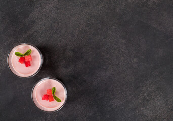 Vegan Red Plum Cream jelly dessert, Panna Cotta in a glass. Dark gray background. Top view. Copy space