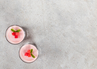 Red Plum Cream jelly dessert, Panna Cotta in a glass. Light gray background. Top view. Copy space