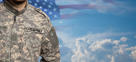 USA soldier in uniform on sunset sky background with USA flag. Memorial Day or Veterans day concept.