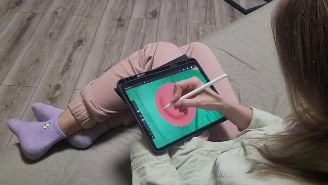 The girl draws on a graphics tablet. Draw a greeting card. Christmas tree.
Spend some free time. The artist draws. Spend free time at home.