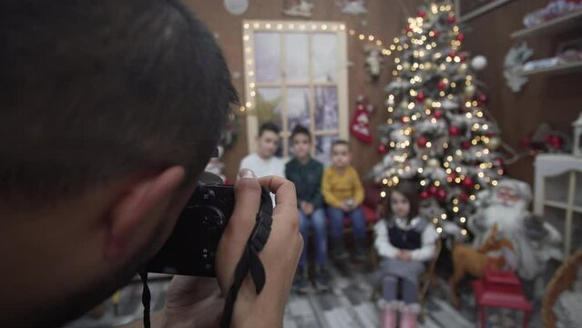 Photograph make authentic Santa Claus photos with little children indoors in studio