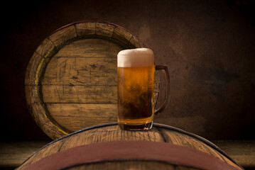 Oktoberfest beer barrel and beer glasses with wheat and hops on wooden table. High quality photo