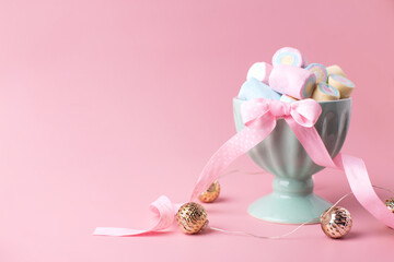 Turquoise bowl with sweet candy marshmallows  on pink pastel background. Place for text. Postcard for birthday, Valentine day, birthday congratulations.