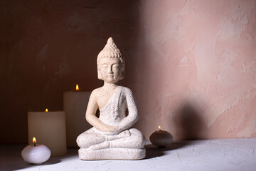 Beauty wellness concept with statue of Buddha  and with burning candles for spa time.  Religion...