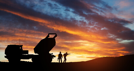 Artillery rocket system are aimed to the sky and soldiers at sunset. Multiple launch rocket system....