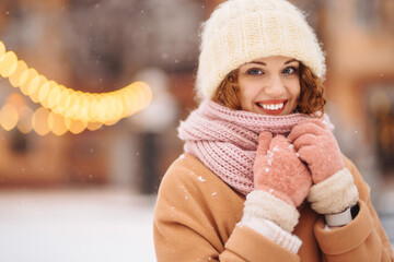 Beautiful woman outdoor during christmas time in front of christmas lights. Holidays, rest, travel...