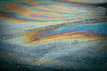 Oil gasoline Rainbow leak flows into the sewer in the car parking