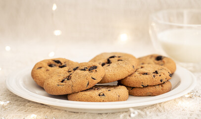 Cookies with chocolate chips close-up and glass of milk.