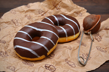appetizing chocolate donuts on parchment paper close-up
