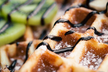 Close-up, Belgian waffles with fruits, covered with chocolate.