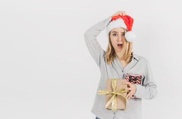 Young blonde woman in a Santa hat holds gifts in her hand and surprised on a white background