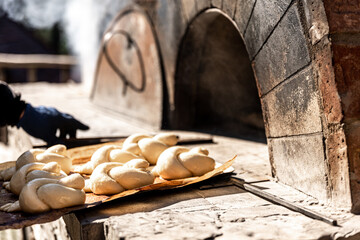 Baking buns in a traditional old oven outside.