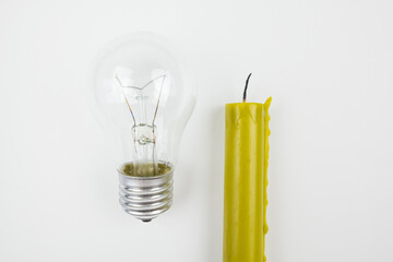 Electric lamp and candle on a white background. Incandescent lamp and candle. Power outage.