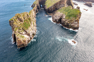 The cliffs and sea stacks An Tor Mor and the Wishing Stone at Port Challa on Tory Island, County Donegal, Ireland © Lukassek