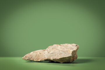 Mockup scene with stone on green background. Natural pedestal for cosmetic product presentation or...