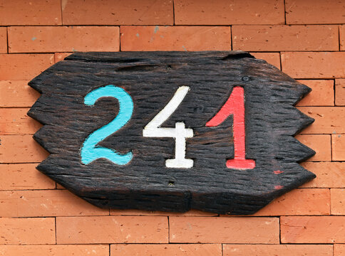 Street sign number 241 on a brick wall
