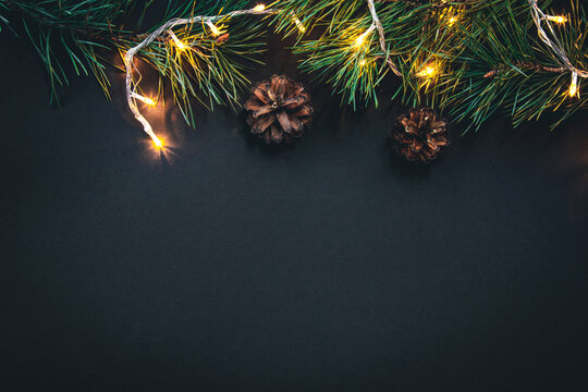 Christmas background with Christmas tree branches and garland, flat lay.