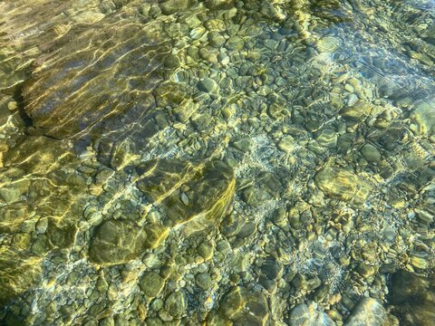 Seabed with stones, pebbles, gravel, boulders in transparent water.
