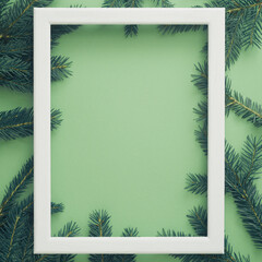 vertical Christmas frame with fir branches. mint green background. pastel color.