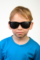 A little boy in black medical glasses for vision correction. Vertical framing.