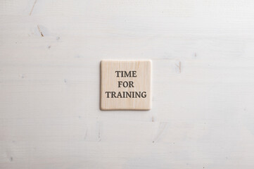 Wooden tile with a Time for training sign on it