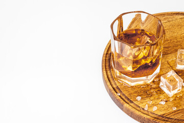 Golden whiskey in glass with ice. Strong alcohol background