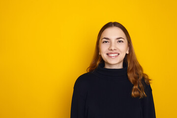 portrait of a smiling girl on a yellow background