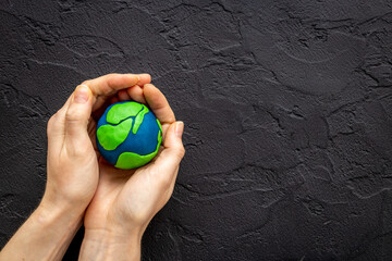 Handmade clay world in hands. Eco and Earth Day concept