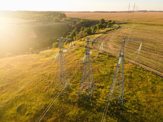 Aerial wide slide shot of High voltage power lines at sunset