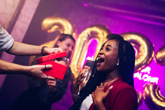 Diverse couple exchanging gifts while on the birthday party or new years eve