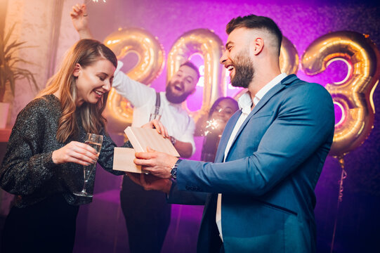 Couple exchanging gifts for birthday party or new years eve in the club