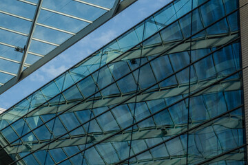 Obraz premium Modern business office building with glass facade on a blue sky background