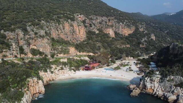 Aerial view of gorgeous Buyuk Chakil (black pebble) beach with emerald clear waters and boats, Kas, Turkey