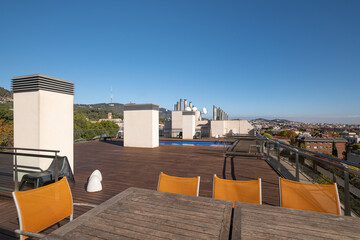 Empty wooden table and chairs on the rooftop with city view